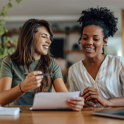 Image of women laughing looking at a paper