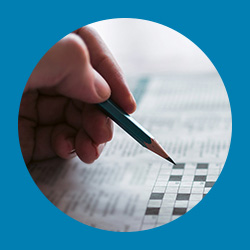 Image of hand holding pencil doing crossword