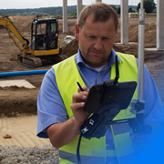 Image of man on construction site looking at tablet