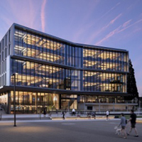 Man and woman in discussion over a laptop showing 3d measurement