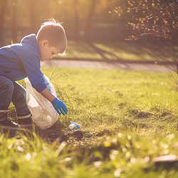 Child outside picking up garbage